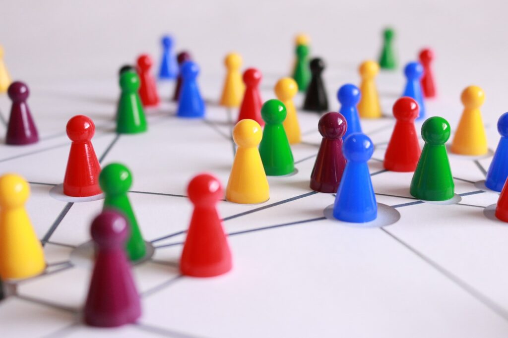 marker pawns from a board game all interconnected to represent the connected community groups