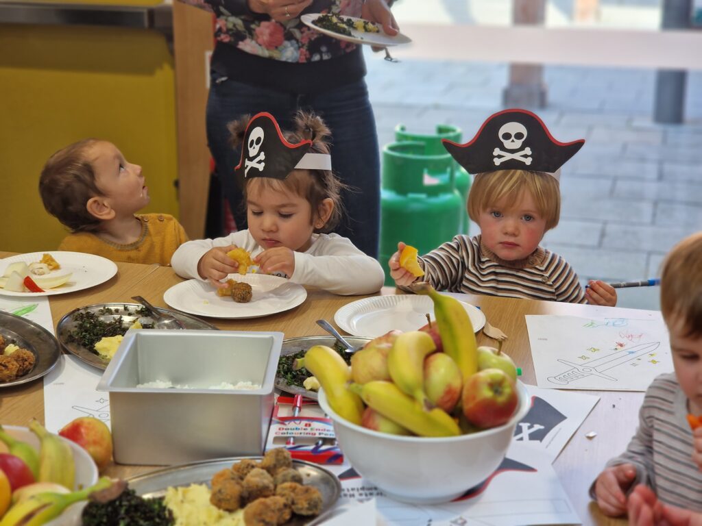 Four young children enjoying food at our Pirate Brunch Community Meal.