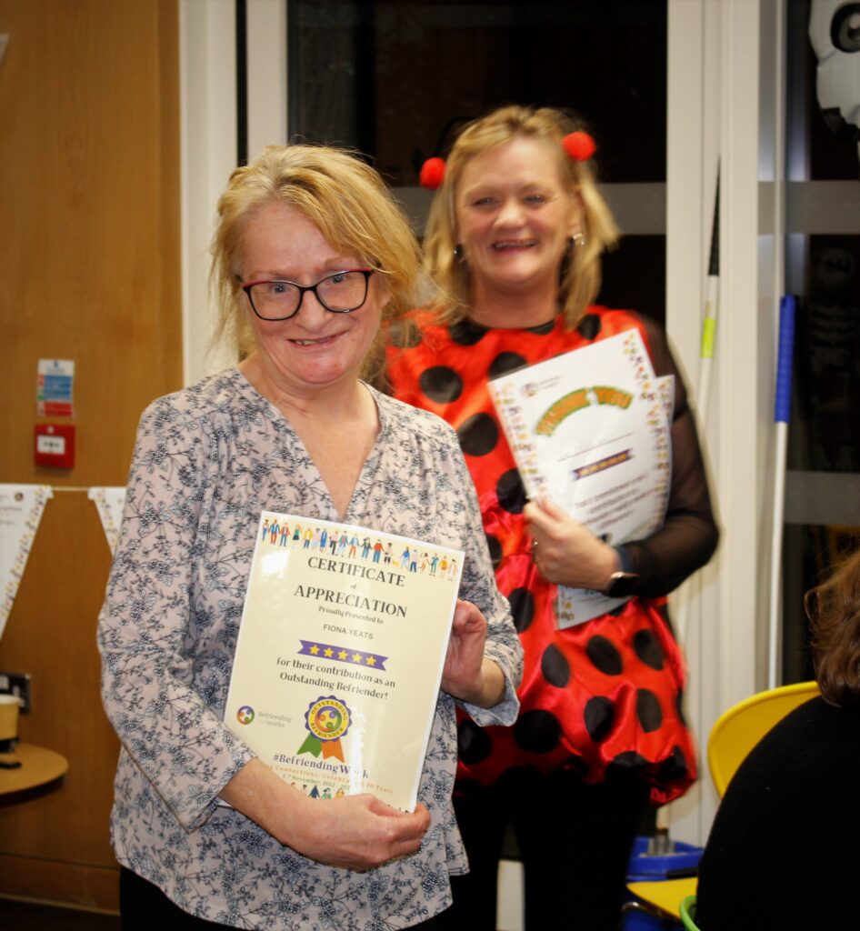 Fiona holds her befriending certificate. Nicola Campbell is in the background